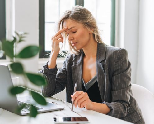 Woman sat at laptop looking sad after being ghosted after an interview