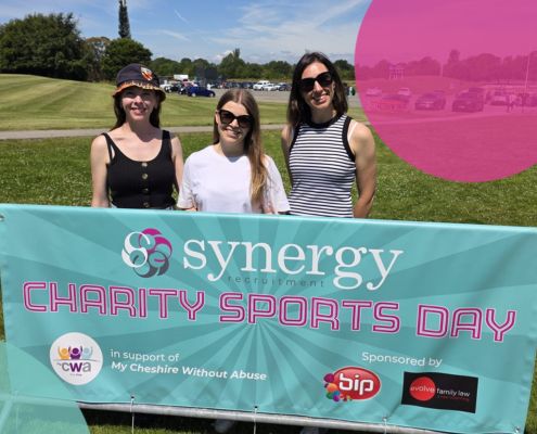 Team Synergy stood behind their Charity Sports Day banner